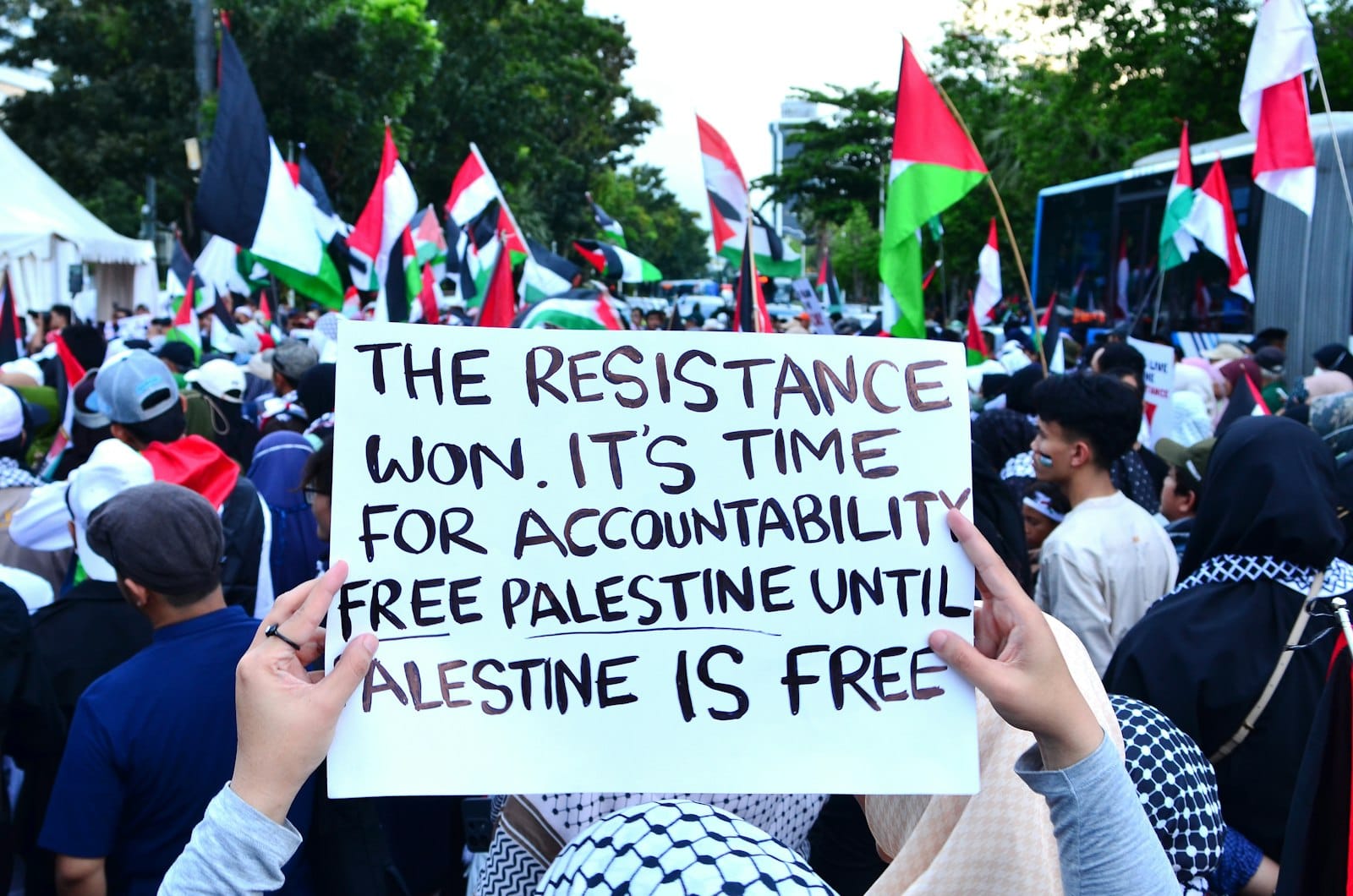 A crowd of people holding signs and flags